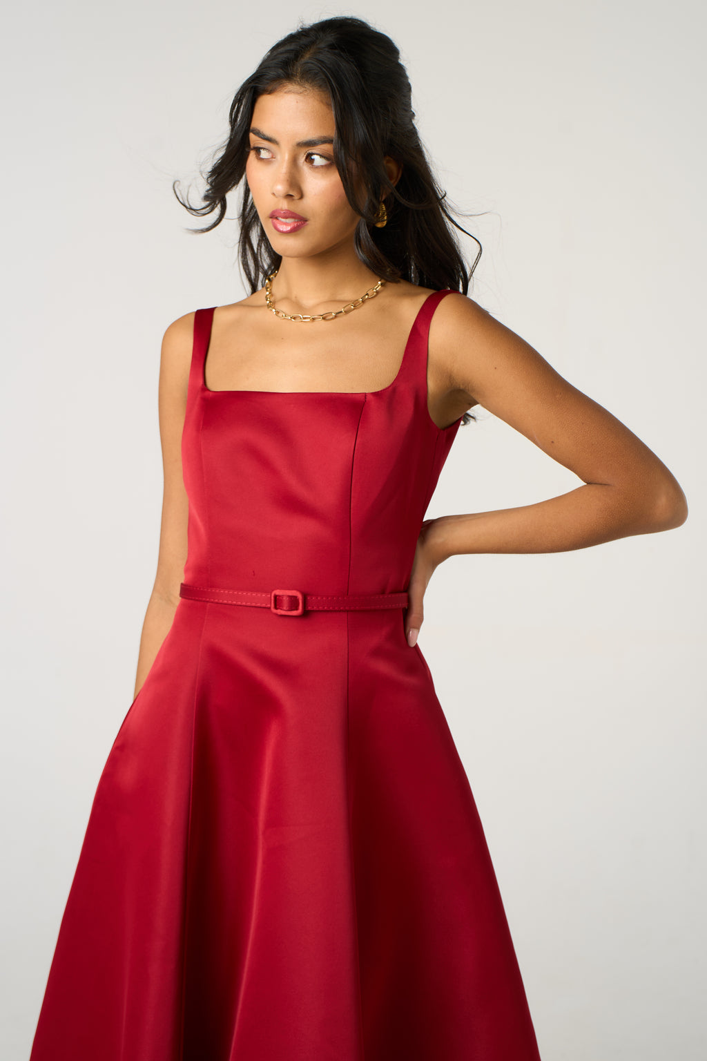 Woman wearing a red dress with a plain background