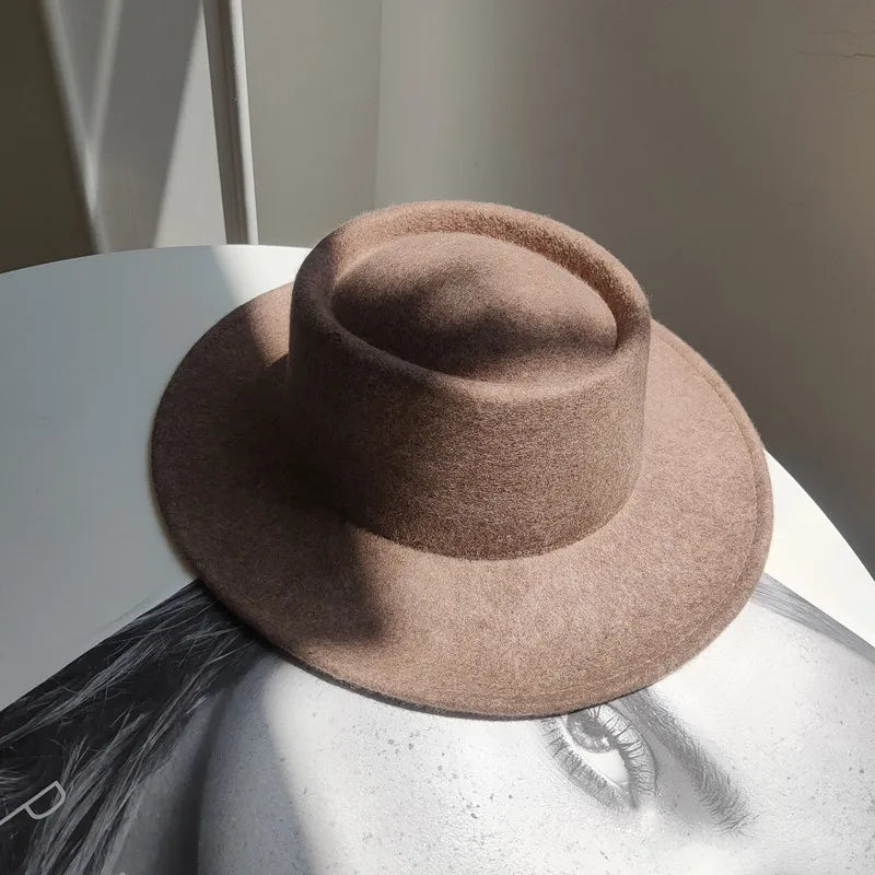 Brown hat on a reflective surface with a neutral background