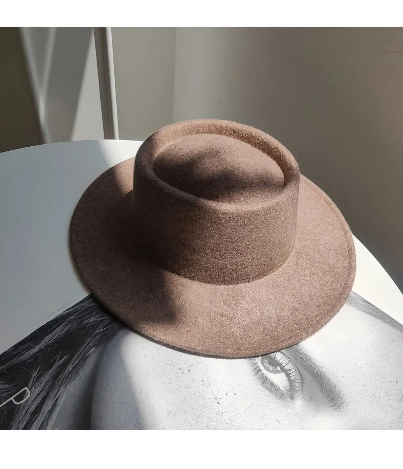 Brown fedora hat on a reflective surface with a blurred background