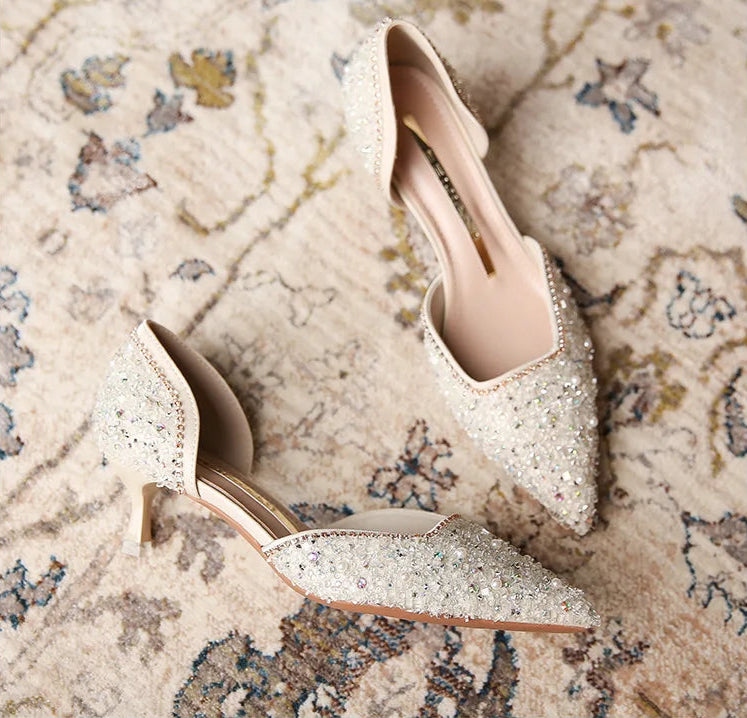 Pair of glittery high-heeled shoes on a patterned surface