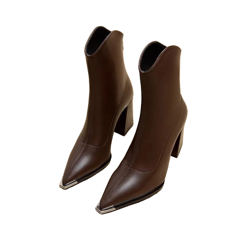 Pair of brown high-heeled ankle boots on a newspaper background