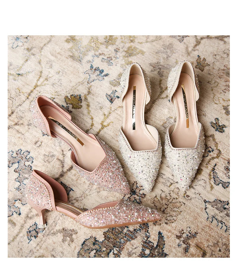 Pair of glittery high-heeled shoes on a textured surface