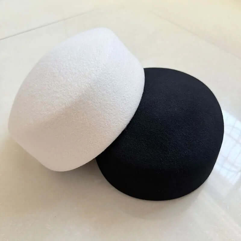 black and white pillbox hats on a white background
