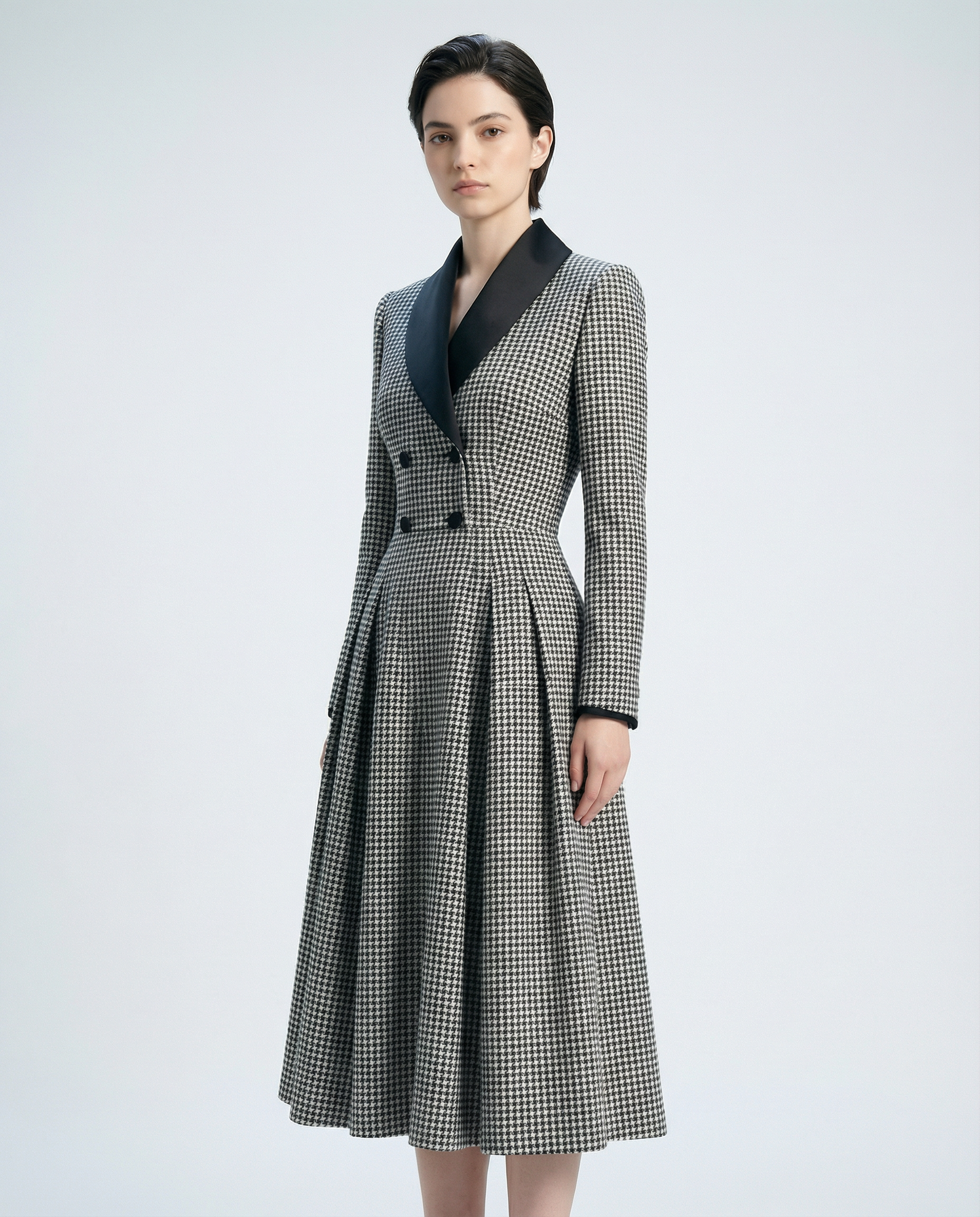 Woman wearing a checkered coat with a black collar on a light gray background