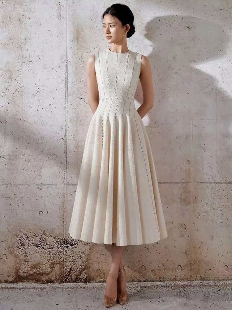 Woman wearing a white dress against a textured wall
