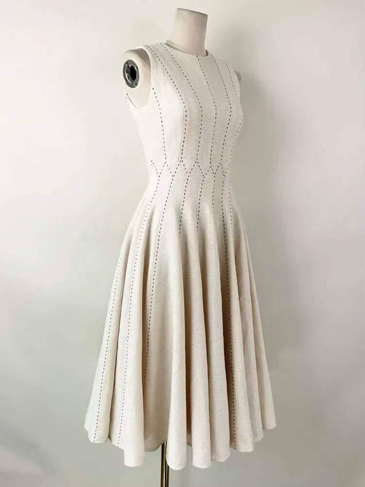 Beige dress on a mannequin against a plain background