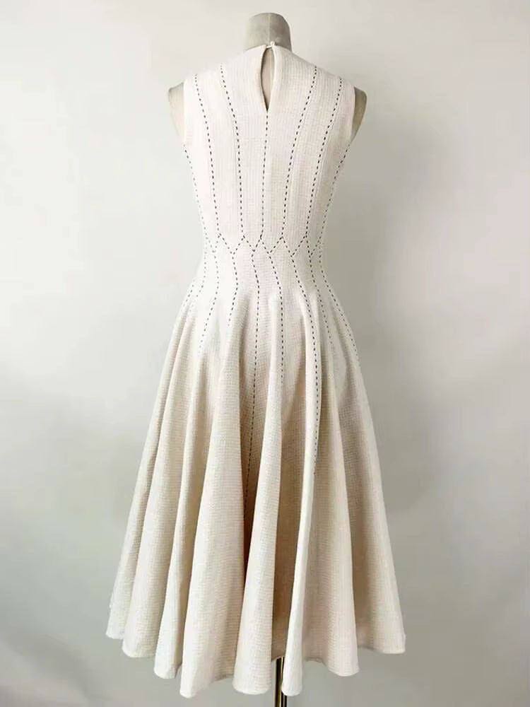 Beige dress on a mannequin against a plain background